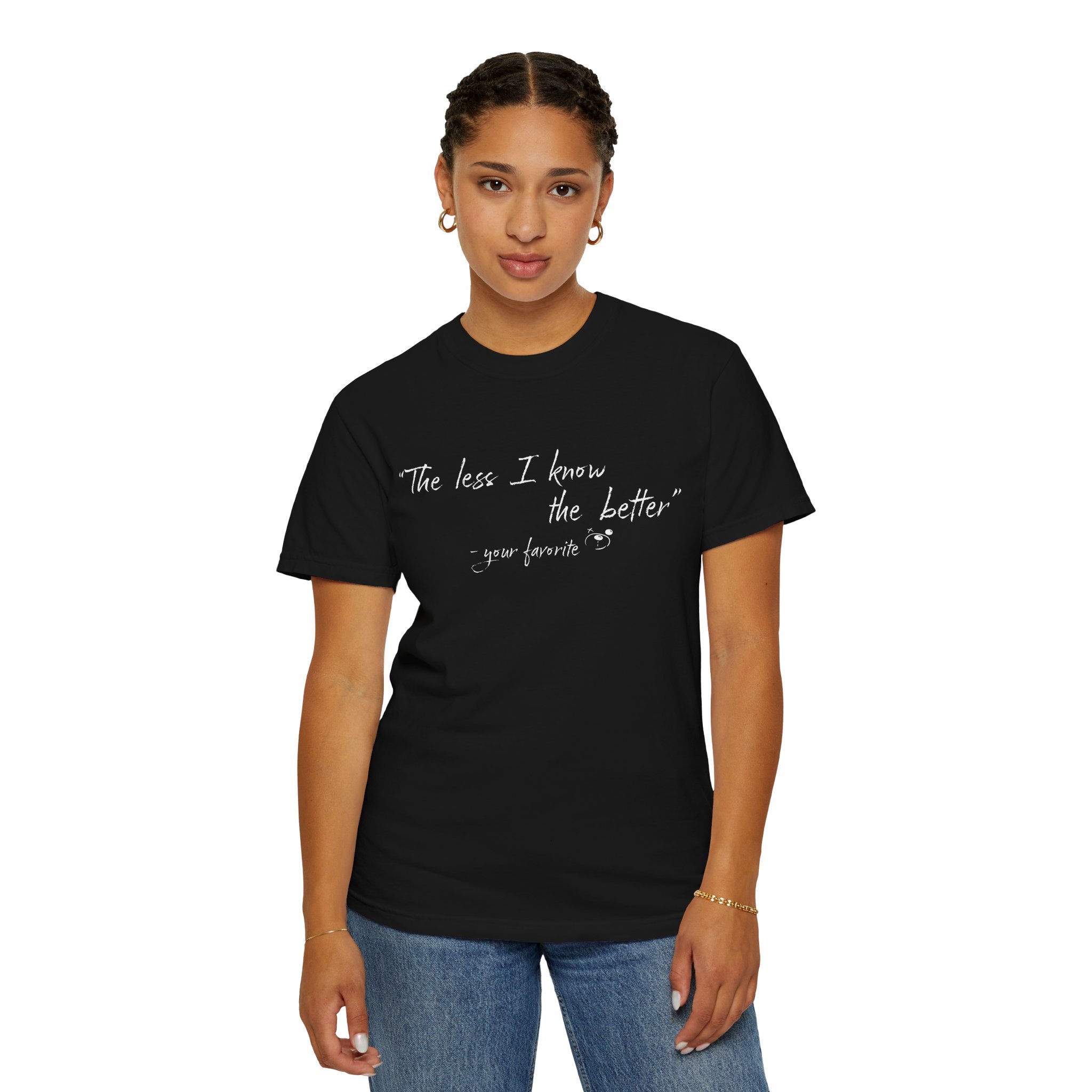 A woman in a black Printify "The Less I Know Tee" featuring the text "The less I know the better – your favorite" stands against a plain white background.