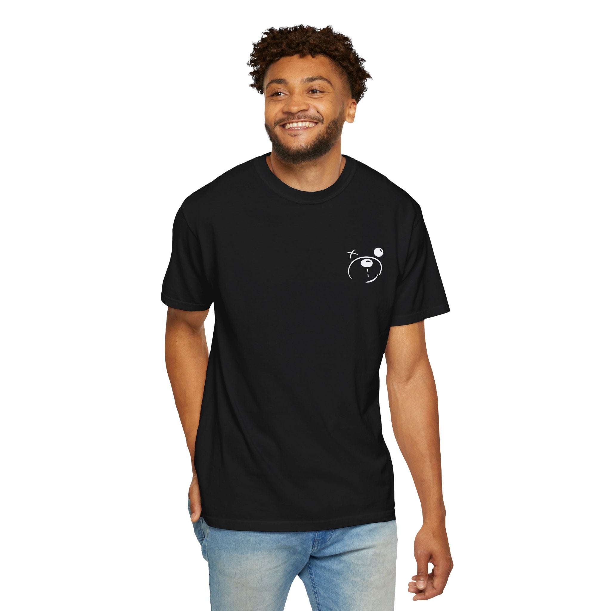A man in jeans stands smiling in a black Transform Tee by Printify. The T-shirt, made from 100% US cotton, sports a small astronaut design on the chest, enhancing his streetwear-style casual look.
