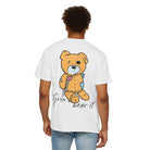 A person models Printify's Grin & Bear It Tee, a white premium US cotton shirt featuring a cartoon bear with a crutch and "Grin & bear it" text on the back.