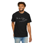 A man faces forward, smiling, wearing Printify’s The Less I Know Tee (Comfort Colors 1717) in black with white text: "The less I know the better - your favorite.