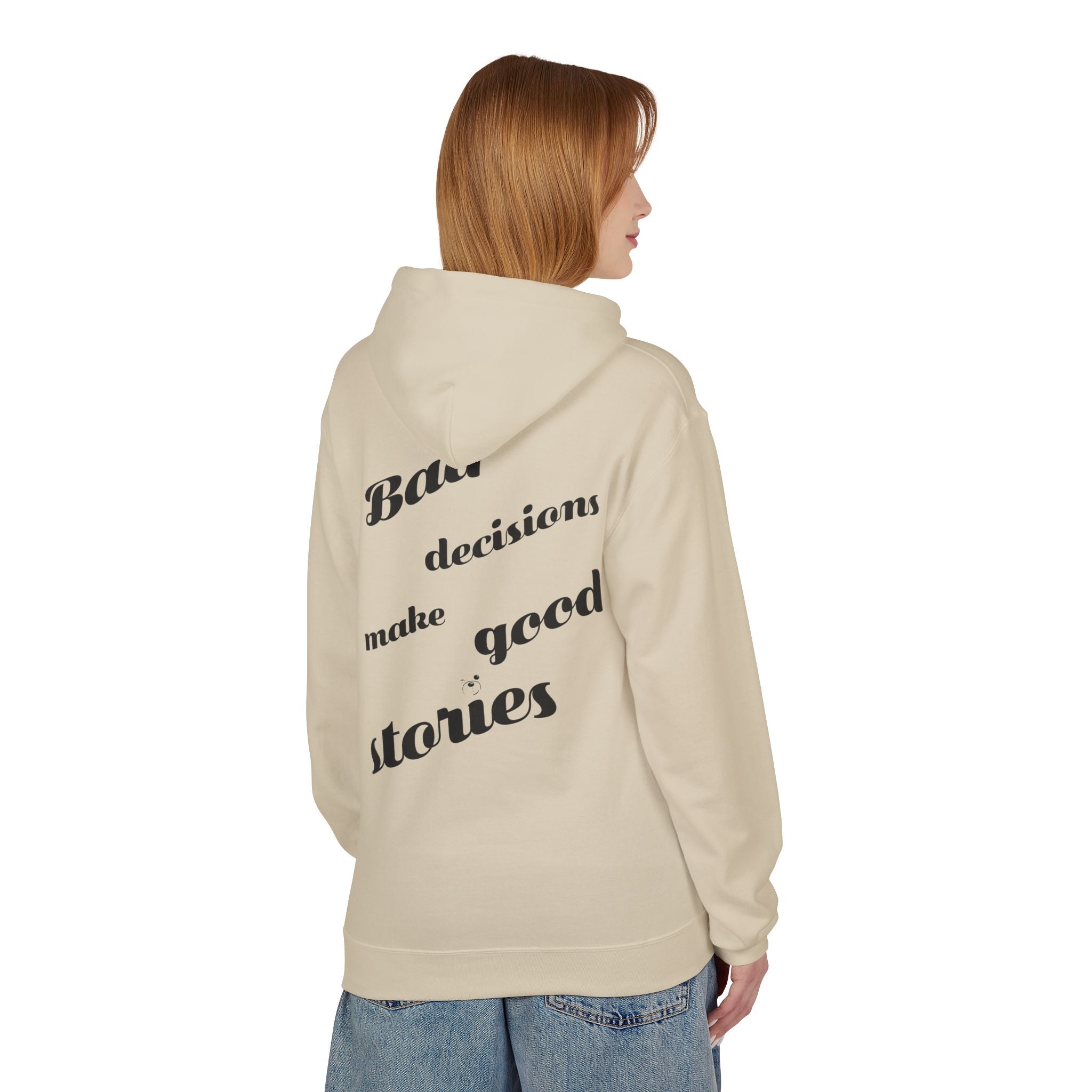 A person models a beige "Bad Decisions Make Good Stories" hoodie from Printify, emphasizing its ethical and eco-friendly traits, paired with blue jeans against a white backdrop.