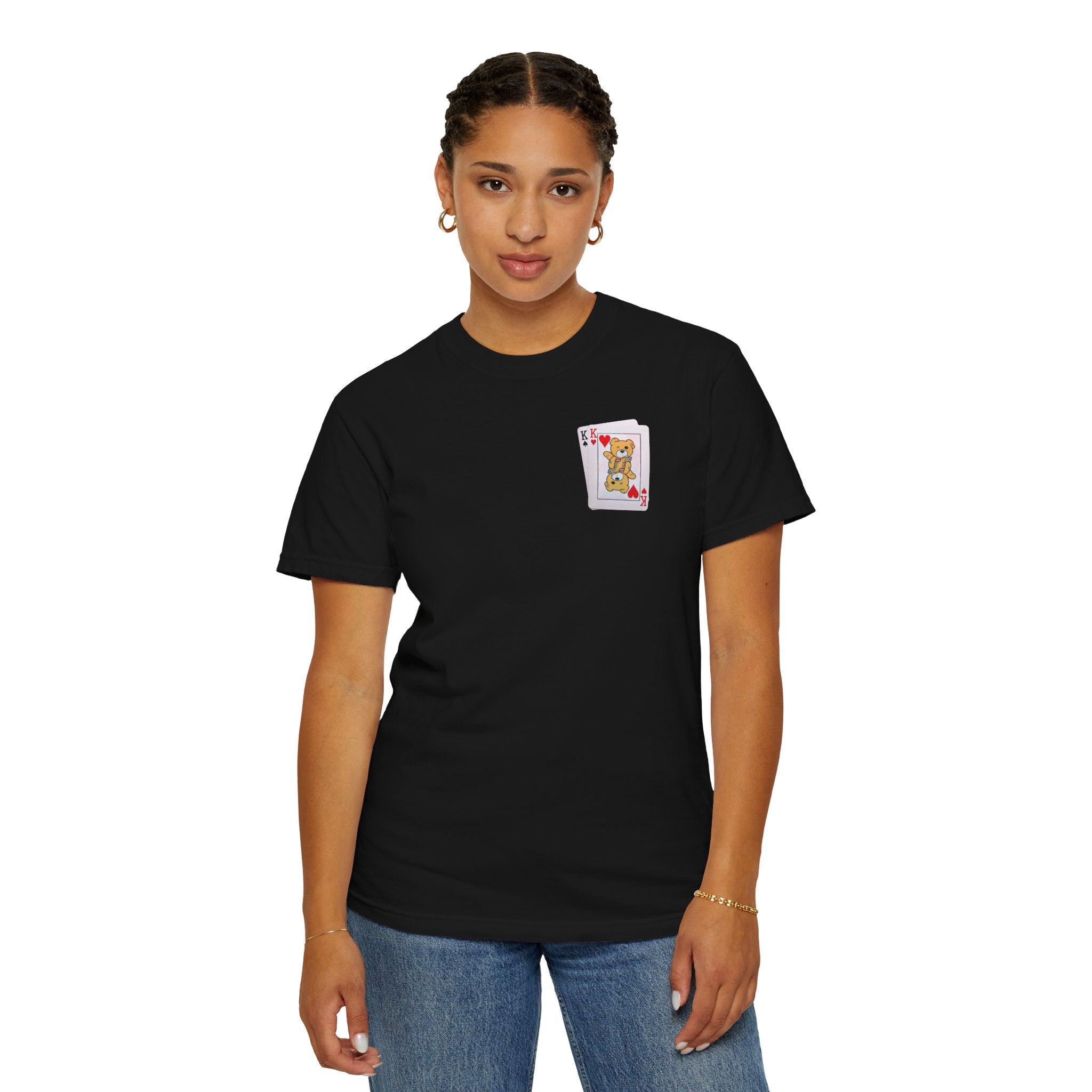 A person in Printify's "Bet on Better not Tee," a black Comfort Colors 1717 shirt made from ethically grown cotton with a small playing card design, paired with blue jeans against a plain backdrop.