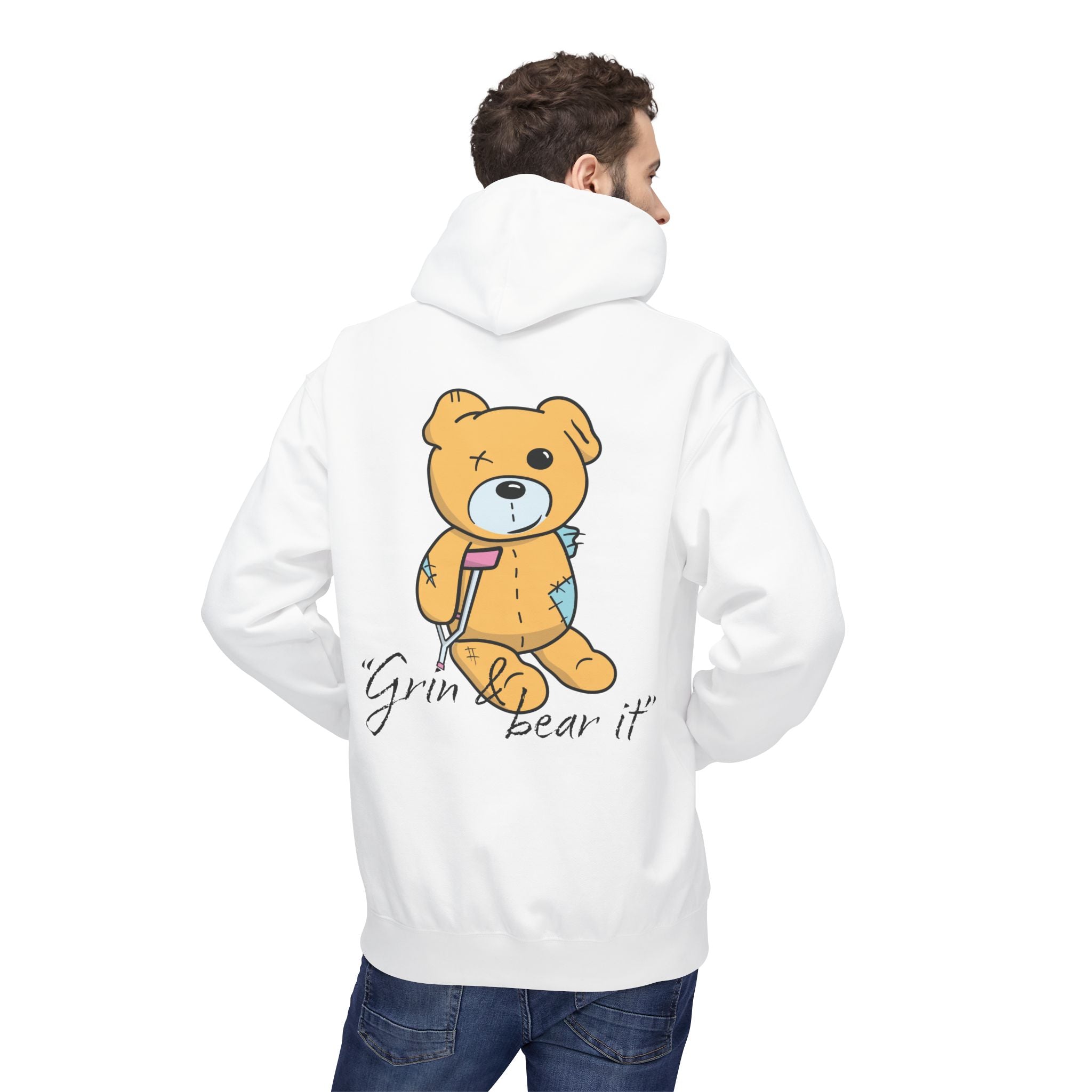 Someone wears the Grin & Bear It Hoodie from Printify, an eco-friendly garment showcasing a patched-up teddy bear graphic with the phrase "Grin & bear it" on the back, promoting sustainable fashion.