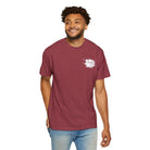 A man smiles against a plain background, wearing a maroon Graffiti Bear Tee by Printify, made from 100% US cotton and featuring a small white graphic on the chest.