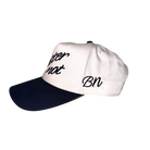 A white and navy 5-panel hat with the phrases "better not" and "bn" embroidered in black script on the front of The Classic hat by Better Not.
