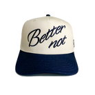 The Classic by Better not is a light cream cap with a white crown and a dark blue bill that features 3D embroidered artwork. The text on the front reads "Better not" in cursive font, adding a touch of flair. Its snapback closure ensures a comfortable fit for all.