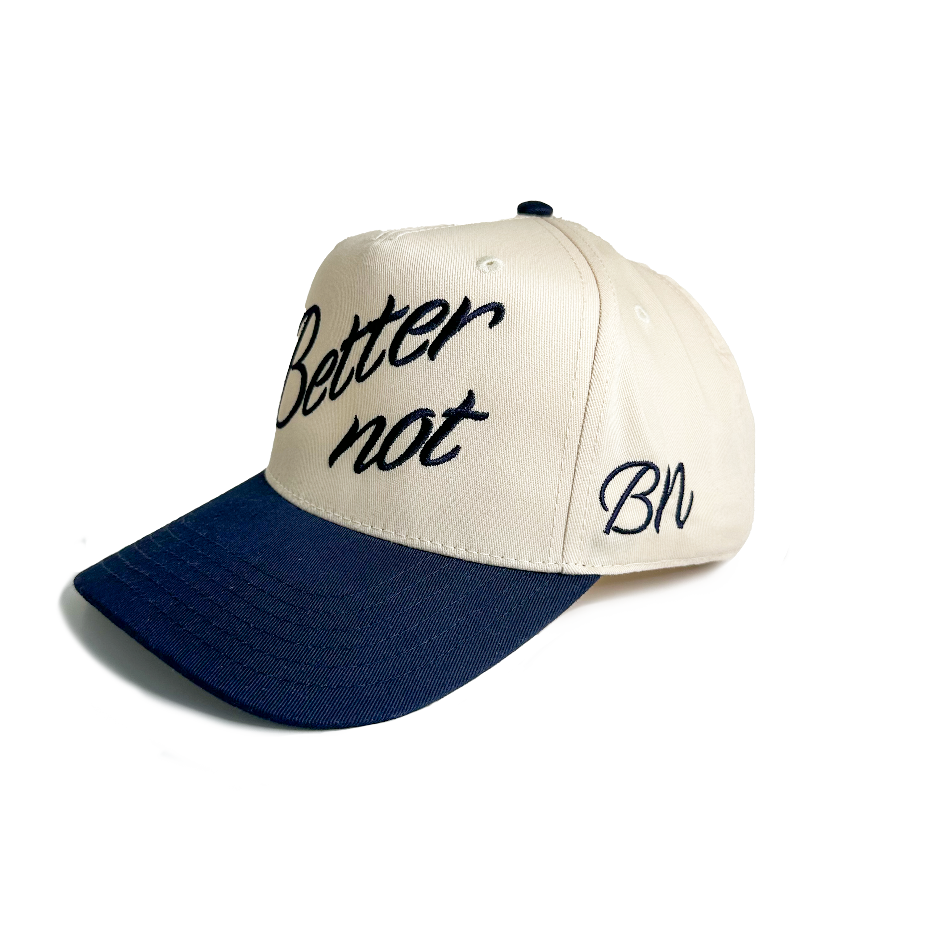 Introducing "The Classic" by Better not—a stylish baseball cap featuring a light cream and dark blue design. It boasts "Better not" intricately 3D embroidered on the front, with "BN" on the side, and is completed with a convenient snapback closure.