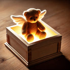 The "Mystery Box" by Better not features a winged teddy bear that glows from within a wooden box, ideal for displaying among cherished items.