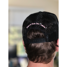 Rear view of a person wearing a Better not Classic Trucker (mid crown) with the phrase "have fun be safe" in pink.